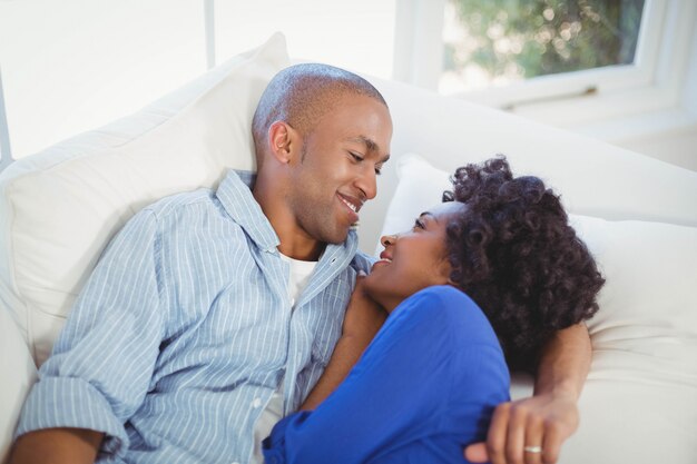 Feliz pareja recostada en el sofá de la sala de estar