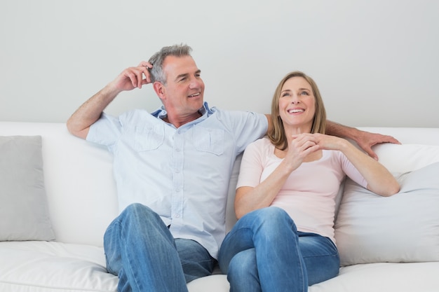 Feliz pareja relajada, sentado en el sofá