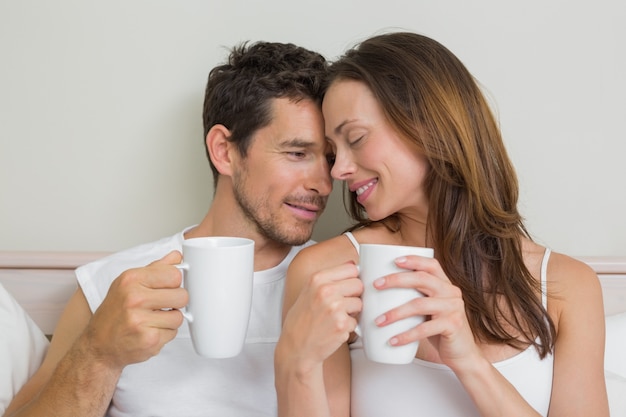 Feliz pareja relajada con tazas de café