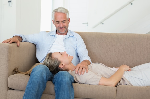 Feliz pareja relajante en el sofá junto