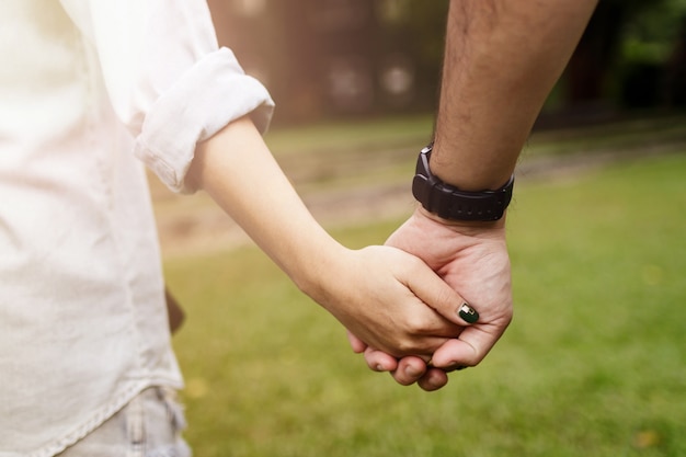 Foto feliz pareja romántica en el amor de la mano y caminando juntos en el parque