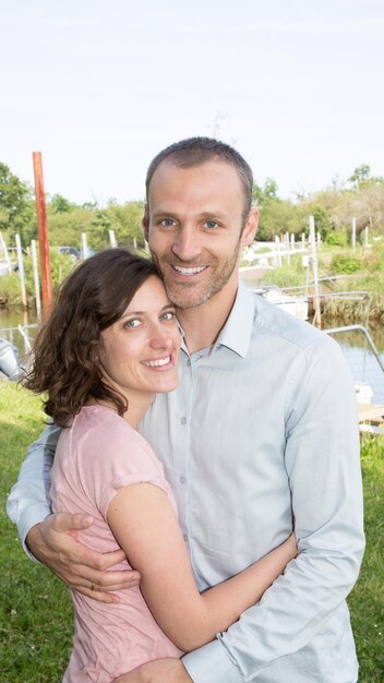 Feliz pareja romántica enamorada en el puerto del lago al aire libre en verano