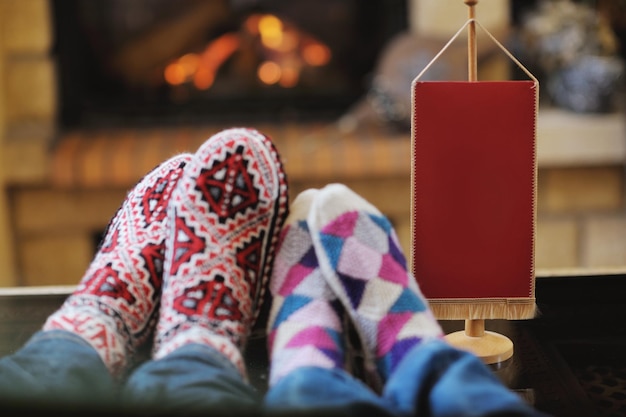 feliz pareja romántica joven y sofá relajante frente a la chimenea en la temporada de invierno en casa