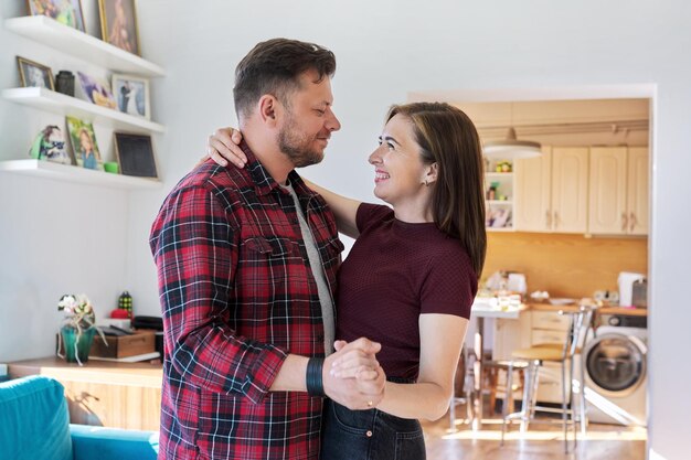 Feliz pareja romántica de mediana edad bailando en casa