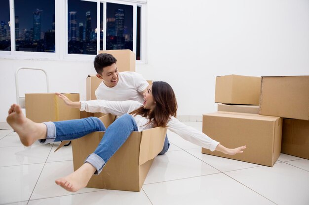 Feliz pareja romántica montando en una caja de cartón