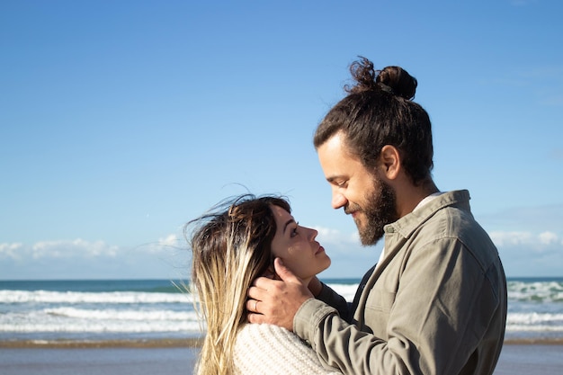 Feliz pareja romántica pasando tiempo en la orilla del mar