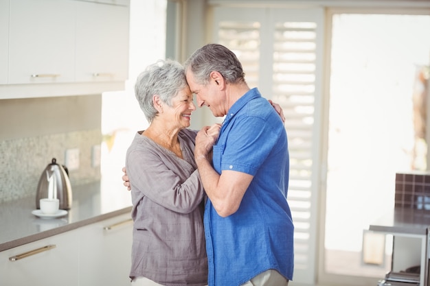 Feliz pareja romántica senior en la cocina