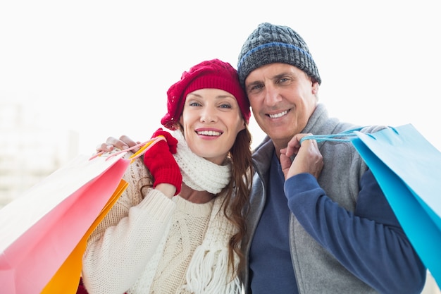 Feliz pareja en ropa de abrigo con bolsas de compras