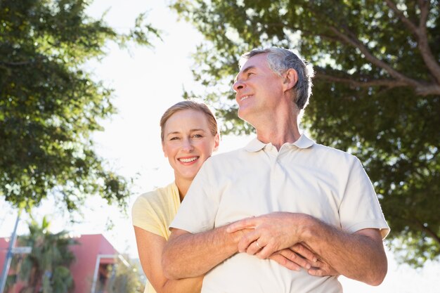 Feliz pareja senior abrazando en la ciudad