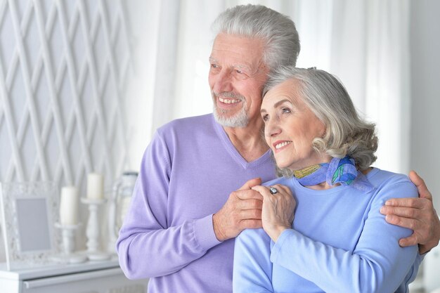 Feliz pareja senior abrazándose en casa