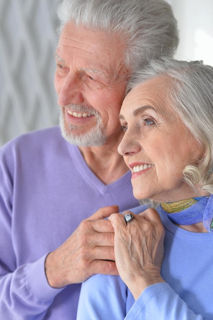 Feliz pareja senior abrazándose en casa