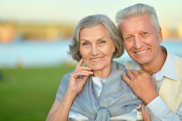 Feliz pareja senior abrazándose en el fondo de la naturaleza