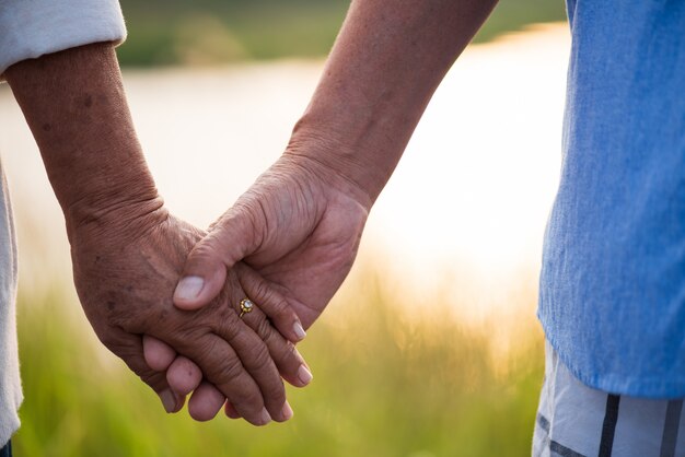 Una feliz pareja senior anciano asiático y una mujer cogidos de la mano