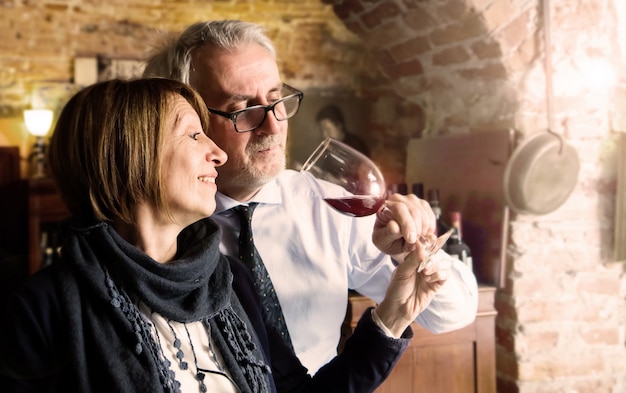 Feliz pareja senior bebiendo una copa de vino