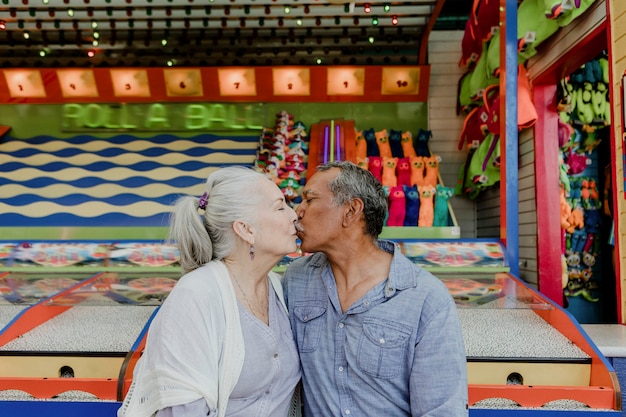 Feliz pareja senior besándose por un puesto de juego