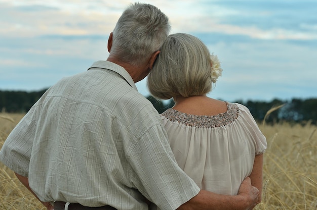 Feliz pareja senior en campo de trigo