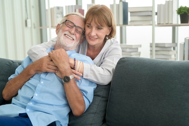 Feliz pareja senior caucásicos relajándose en la sala de estar en casa