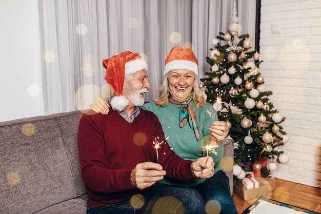 Feliz pareja senior celebrando el año nuevo en su casa.