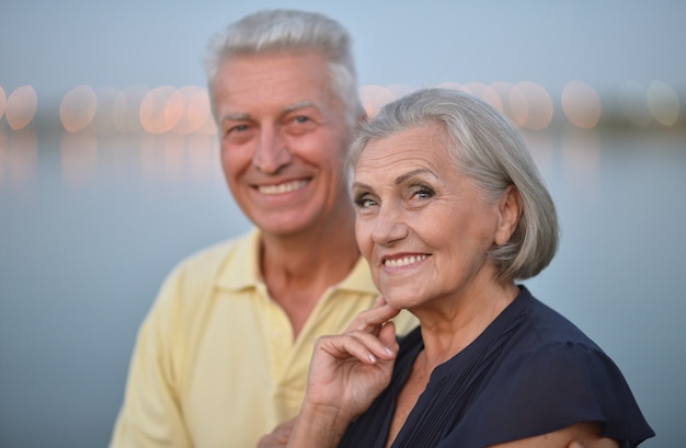 Feliz pareja senior cerca del río en verano