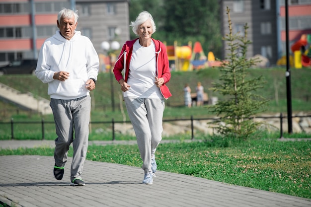 Feliz pareja senior corriendo en el parque