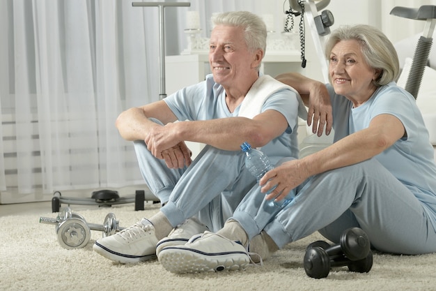 Feliz pareja senior deportiva descansando después de hacer ejercicio
