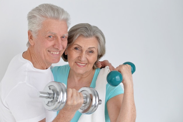 Feliz pareja senior deportiva haciendo ejercicio con pesas