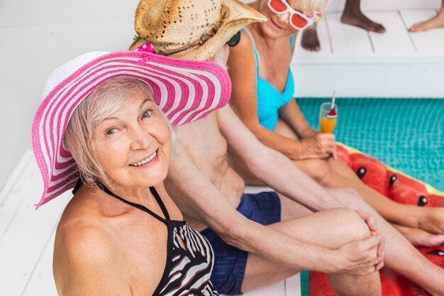 Feliz pareja senior de fiesta en la piscina