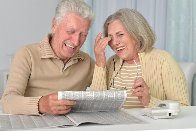 Foto feliz pareja senior leyendo periódico