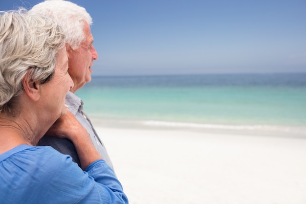 Feliz pareja senior mirando al mar