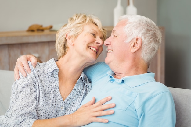 Feliz pareja senior mirándose mientras abrazaba