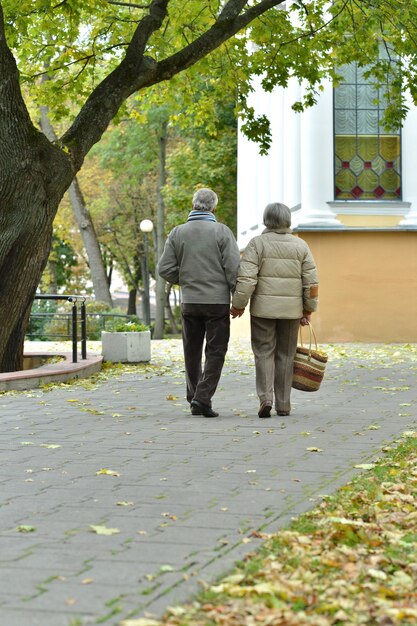 Foto feliz pareja senior en otoño parque caminando