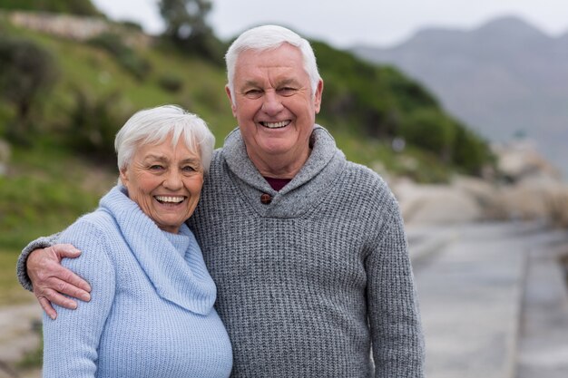 Feliz pareja senior de pie juntos en la playa