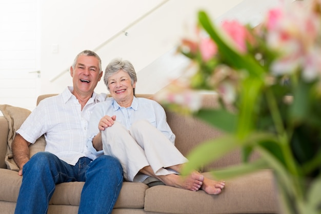 Feliz pareja senior relajarse en el sofá