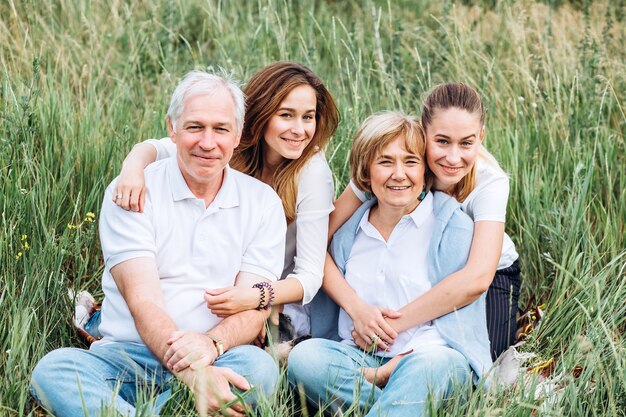 Feliz pareja senior con sus hijas en la naturaleza