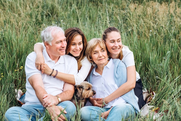 Foto feliz pareja senior con sus hijas en la naturaleza