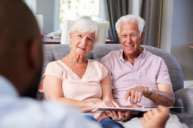 Feliz pareja senior tomando consejos financieros en casa