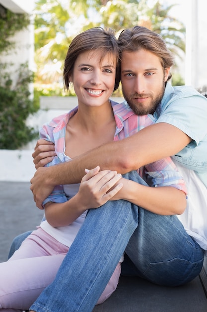 Feliz pareja sentada y abrazados