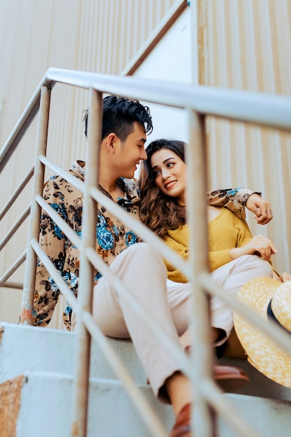 feliz pareja sentada en las escaleras