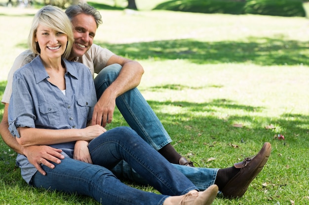 Feliz pareja sentada en el parque