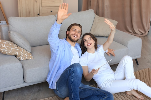 Feliz pareja sentada y planificando la nueva decoración del hogar en casa  con una tableta, renovación y diseño de interiores para la nueva casa. |  Foto Premium