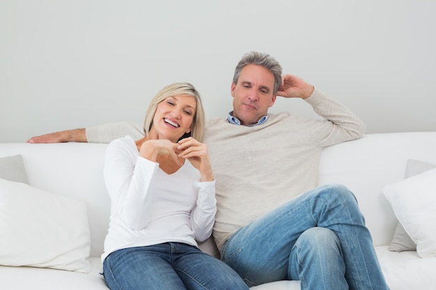 Feliz pareja sentada en la sala de estar