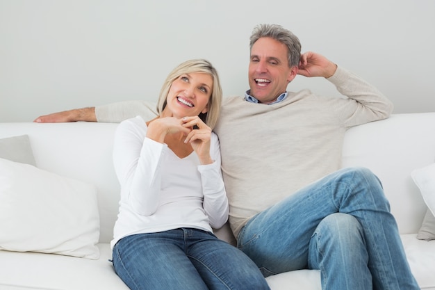 Feliz pareja sentada en la sala de estar