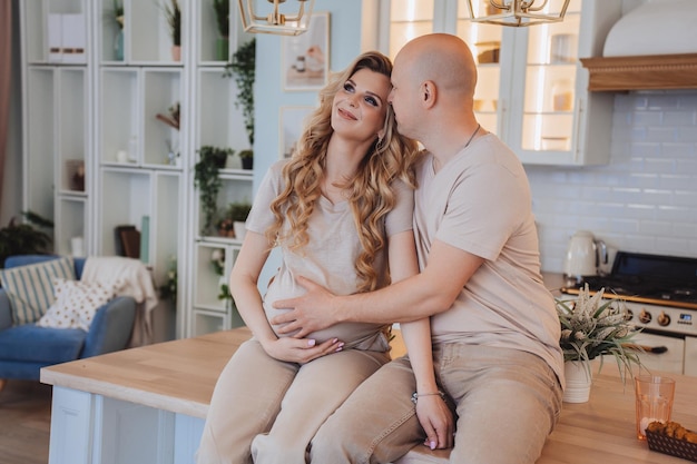 feliz, pareja, sentado, en, un, mesa de la cocina, rubio, embarazada, mujer caucásica, con, marido, hogar