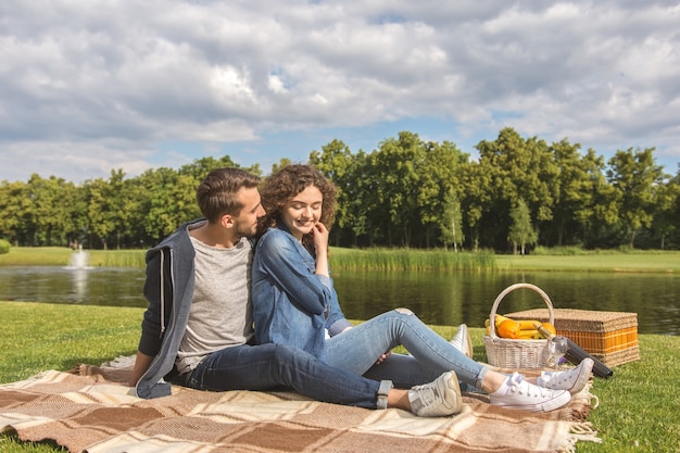 La feliz pareja se sienta en la portada cerca del río.