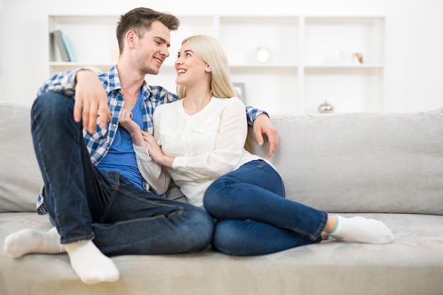 La feliz pareja se sienta en el sofá