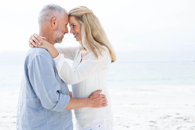 Feliz pareja sonriendo el uno al otro junto al mar