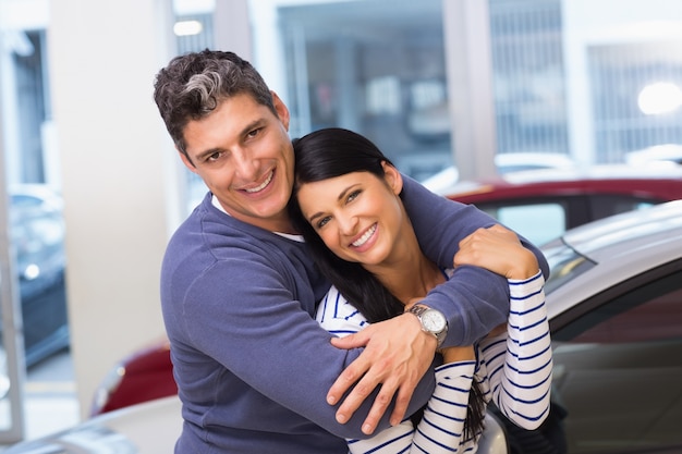 Feliz pareja sonriendo a la cámara y abrazar