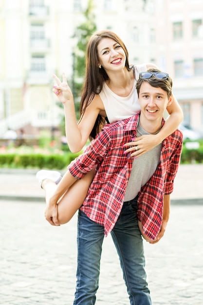 Feliz pareja sonriente divirtiéndose en la calle en verano