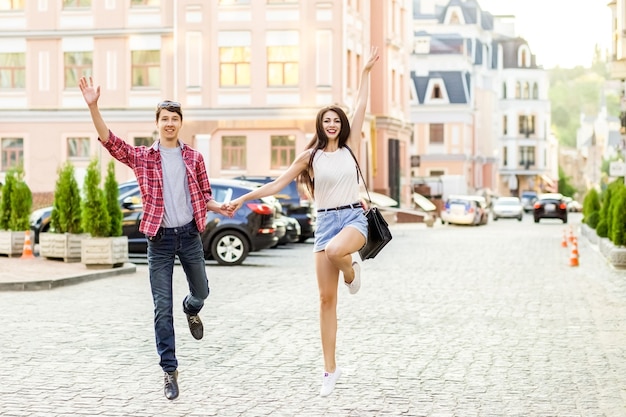 Feliz pareja sonriente divirtiéndose en la calle en verano