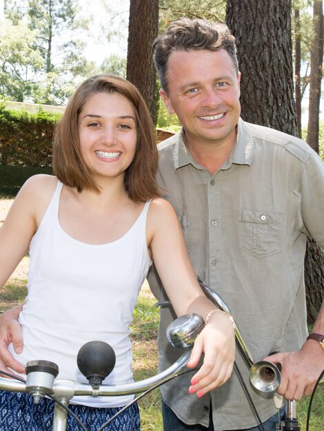 Feliz pareja sonriente montando en el parque